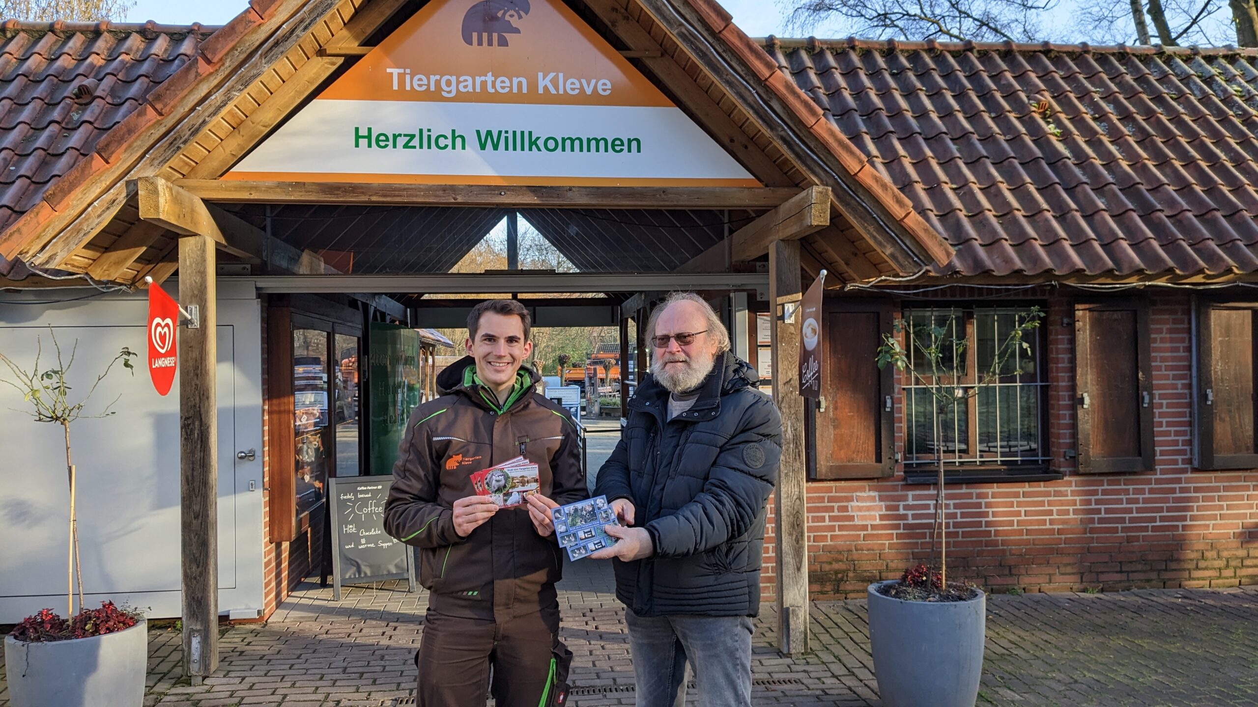 Helmut Heckmann (Schleusen Verein Brienen) übergibt die Postkarten an Tiergartenleiter Martin Polotzek
